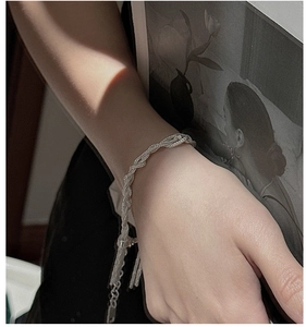 Macro shot of S925 sterling silver multi-layer woven chain bracelet with tassels