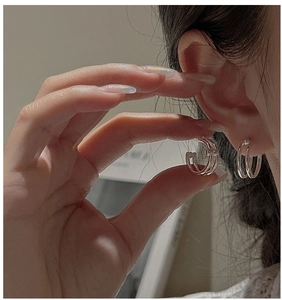 Close-up of minimalist S925 sterling silver triple-layered hoop earrings worn on ear