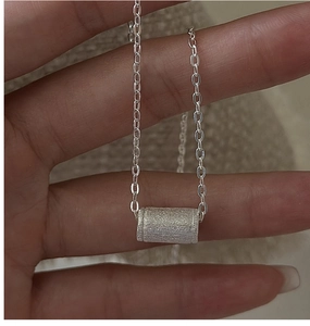 Dettaglio della collana a cilindro in argento sterling S925 con texture opaca spazzolata