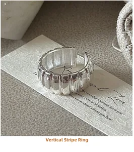 Macro shot of silver S925 ribbed wide open ring on vintage aesthetic paper card