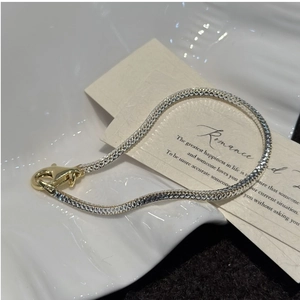 Detail of s925 silver snake chain bracelet with two-tone finish and lobster clasp