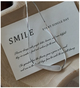 Close-up of minimalist S925 sterling silver snake chain with matte finish bar pendant