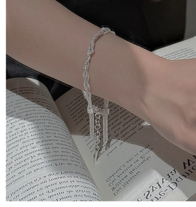 Detail of silver S925 multi-strand braided bracelet on wrist with adjustable tassel chain