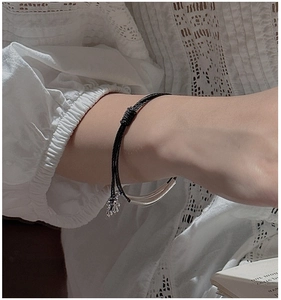 Detail of minimalist S925 silver triple-layered braided rope bracelet on a woman wrist