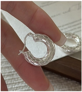 Detail of 3D fish scale texture and S925 silver hallmark on chunky hoop earrings