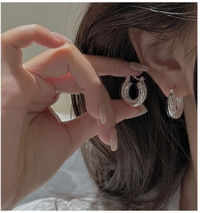 Close-up of S925 sterling silver hoop earrings with vintage twisted texture on earlobe