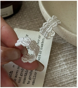 Gros plan détaillé des boucles d'oreilles C en argent S925 avec texture tissée creuse