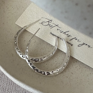 S925 sterling silver hoop earrings with hammered texture on a beige ceramic tray