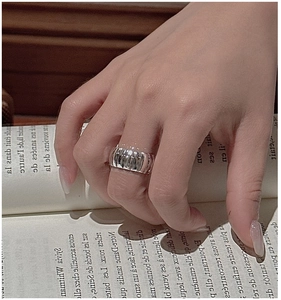 Close-up of wide S925 silver ring featuring a textured vertical pleated croissant pattern