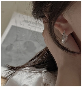 Close-up of S925 silver hoop earring with hollow honeycomb texture on a model ear