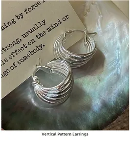 Close-up of S925 sterling silver multi-layered hoop earrings with vertical wave texture