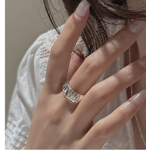 Detailed view of S925 silver wide pleated ring with vertical grooved texture on finger