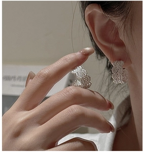 Gros plan sur les créoles en argent S925 avec texture dentelle et design vintage