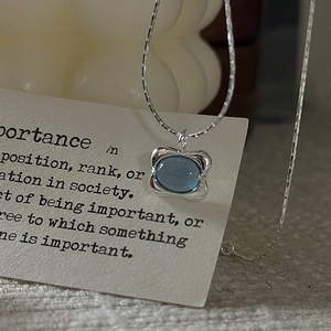 Minimalist S925 silver necklace with an oval light blue stone and wavy edge pendant