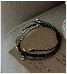 Detail view of S925 silver triple-layered woven cord bracelet on an aesthetic craft card
