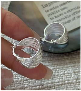 Close-up of S925 sterling silver stamp on minimalist multi-layer textured hoop earrings