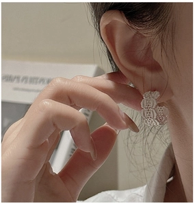 Détail de boucles d'oreilles créoles S925 en argent avec texture dentelle florale