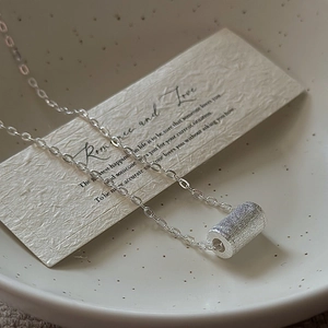 Collana minimalista in argento S925 con pendente cilindrico spazzolato su ceramica