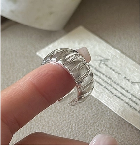 Macro view of sterling silver croissant dome ring featuring polished textured ridges