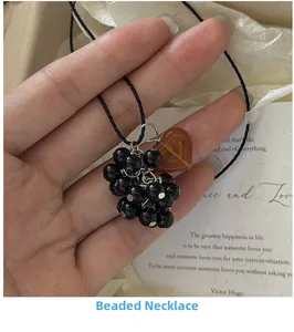 Detailed view of beaded grape cluster necklace with brown heart resin charm and black cord