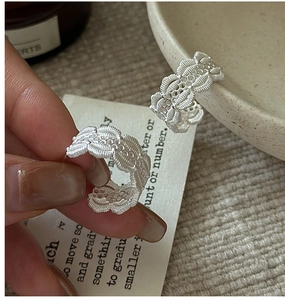 Vue détaillée de boucles d'oreilles C en argent S925 avec texture dentelle et bords ondulés