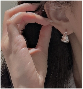 Detailed close-up of S925 sterling silver shell earrings with radial wave textures