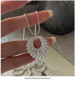 Detailed close-up of S925 sterling silver irregular ripple pendant on a fine ball chain