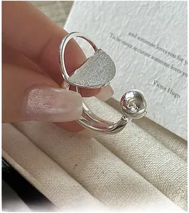Macro detail of a brushed semi-circle and polished bead on a S925 silver ring