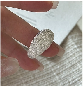 Macro shot of silver ring featuring a textured starry finish and a rounded oval surface