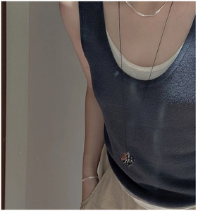 Ethnic style long grape necklace with silver chain layered on dark blue knitwear