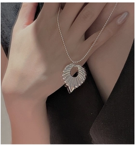Detail of S925 silver hollow heart pendant with sunburst texture on a bead chain