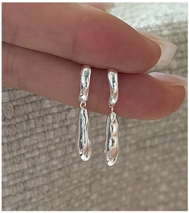 Detailed close-up of S925 sterling silver liquid metal drop earrings with wavy texture