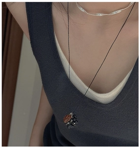 Detail of layered S925 silver choker and black long necklace with amber pendant