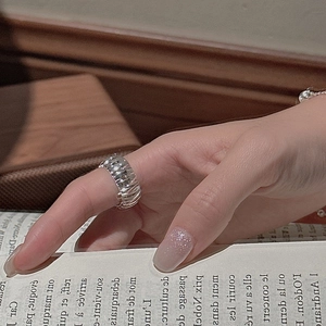 Minimalist S925 sterling silver ring with vertical textures worn over vintage book pages