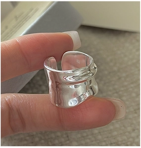Close-up of wide S925 sterling silver ring with irregular hammered wavy texture