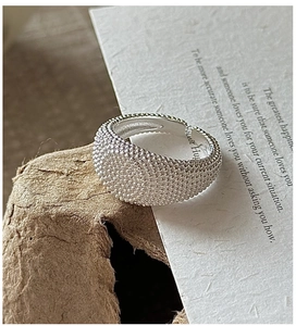 Macro shot of S925 sterling silver wide band ring with vintage beaded texture and engravings