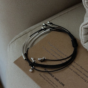 Minimalist S925 silver layered woven bracelets on a vintage gift card background