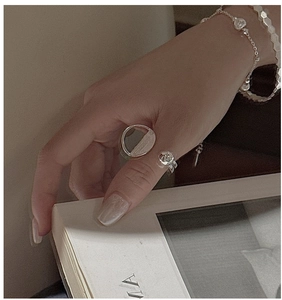 Detail view of silver S925 ring with semi-circle design and small rose flower decor