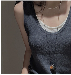 Detail of minimalist S925 silver grape necklace with amber bead on a model