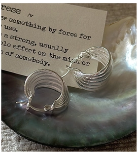 Macro detail of S925 sterling silver earrings featuring a spiral textured ribbed design