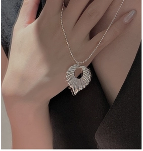 Detail of S925 sterling silver beaded necklace with fan-shaped textured pendant on a model