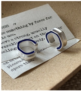 Detail of S925 sterling silver C-shaped ear cuffs with blue enamel and matte finish