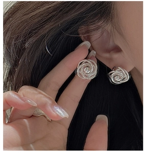Close-up of S925 sterling silver twist earrings with minimalist spiral design on model