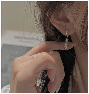Close-up of S925 silver irregular lava texture earrings and matching open ring on model