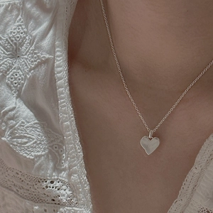 Collier avec pendentif cœur rétro en argent S925 porté sur un haut en dentelle