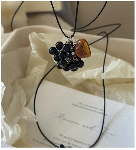 Detailed shot of black beads and amber heart pendant on a vintage silver necklace
