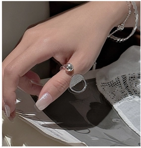 Silver minimalist ring with polished bead paired with elegant beaded bracelets on a hand