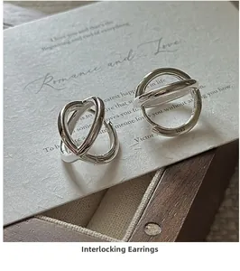 Close-up of S925 sterling silver hoop earrings with overlapping minimalist design