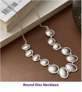 Detailed view of matte S925 silver oval disc necklace on a premium leather background