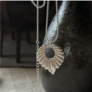 Macro shot of S925 sterling silver hollow shell pendant on vintage bead chain